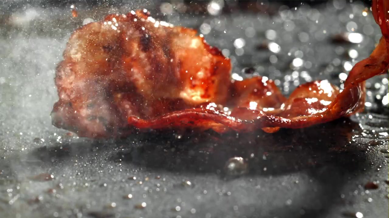 Close-up of Sizzling Bacon Frying on a Hot Griddle
