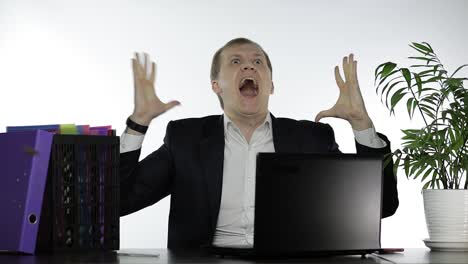 angry businessman screaming at his desk