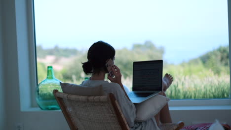 casual business call: young female multitasking in countryside home