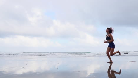 morning bliss: slow motion run of an athletic woman sculpting curves on the beach