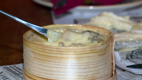 cheese fondue in wooden bowl