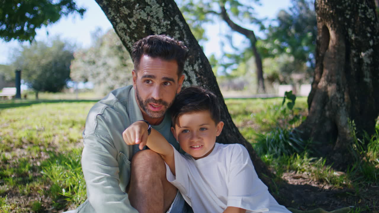 Man sitting garden son looking nature at weekend closeup. Boy holding binoculars