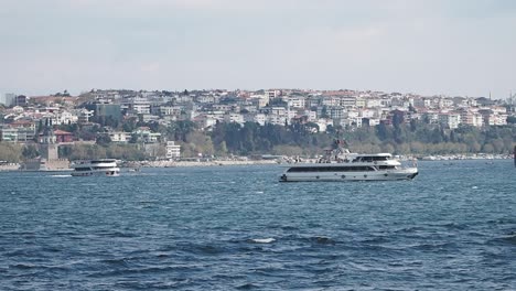 boats sailing on the water with a city shoreline in the background