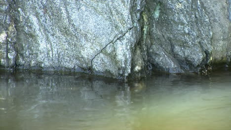 Primer-Plano-De-Rocas-Brillantes-Al-Borde-Del-Agua