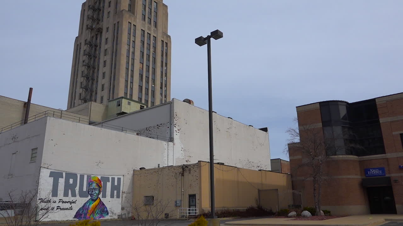 un mural dice la verdad en una pared debajo de un edificio alto en el centro de battle creek, michigan
