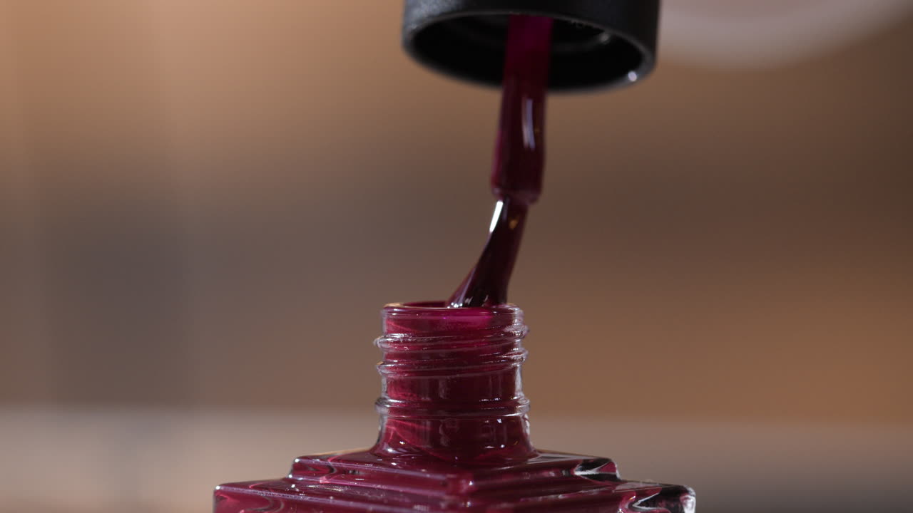 Applying maroon nail polish