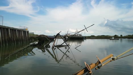 Slow-flight-over-submerged-shipwreck-in-calm-muddy-water-of-the-River-Wyre-at-Fleetwood-Docks-Lancashire-UK