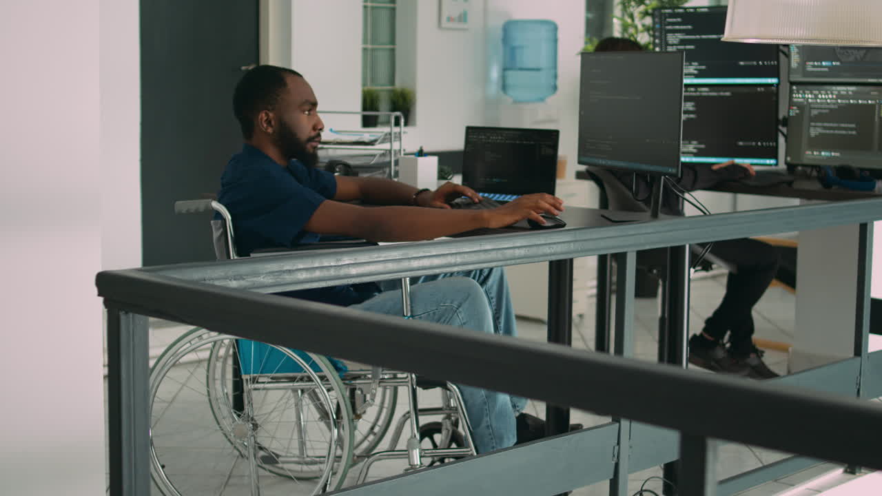 Wheelchair user software engineer working on server program with computer