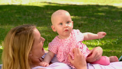 madre acostada con su bebé en el parque