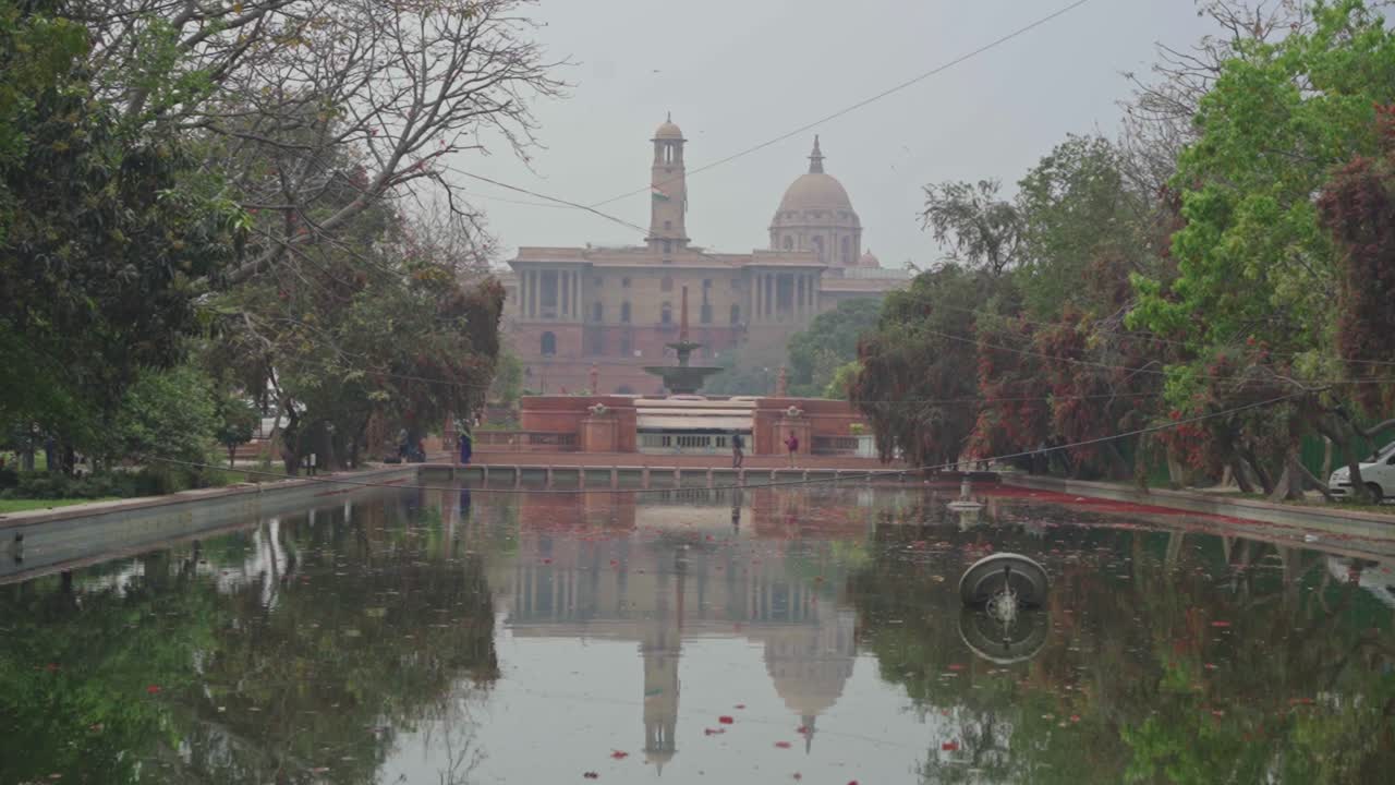 Rajpath ve Central Vista çimleri, Yeni Delhi, Hindistan, Asya'da kötü hava kalitesi, düşük görüş mesafesi, gri duman ve yansımalı sisli bir gökyüzü altında Kartavya Path olarak yeniden adlandırıldı.