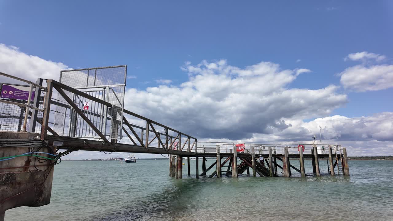 Wooden Pier Near Calshot Beach On Sunny Day In Hampshire, UK. timelapse