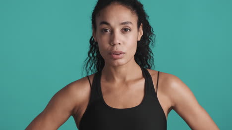 una mujer afroamericana cansada sobre un fondo azul.