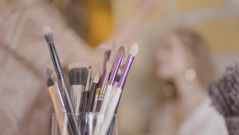 makeup brushes in a glass jar