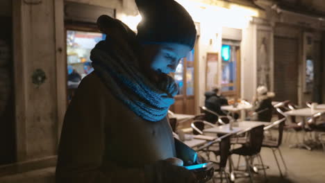 Mujer-Con-Teléfono-Celular-Al-Aire-Libre-Por-La-Noche