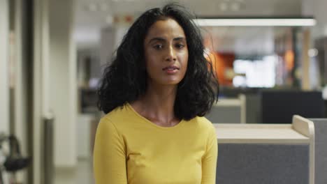 Video-of-smiling-biracial-woman-looking-at-camera-in-office