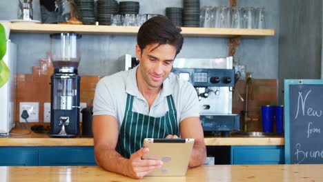 Porträt-Eines-Kellners,-Der-Ein-Tablet-Auf-Der-Theke-Benutzt