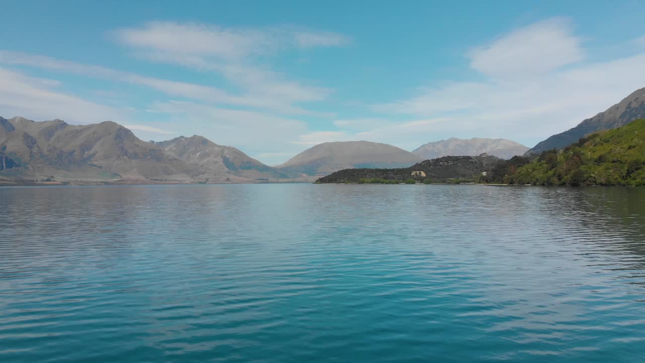 slowmo - полет над озером вакатипу, квинстаун, новая зеландия с горой на заднем плане - аэрофотосъемка