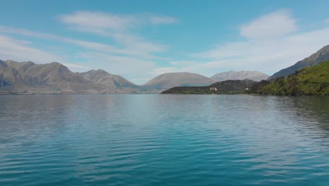 Cámara-Lenta---Volando-Sobre-El-Lago-Wakatipu,-Queenstown,-Nueva-Zelanda-Con-La-Montaña-En-El-Fondo---Antena