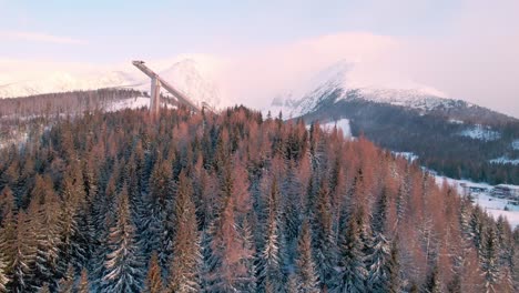 high tatra amazing mountain snowy landscape with ski jump tower, aerial forward