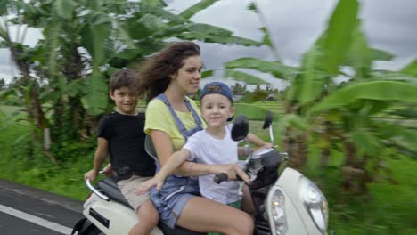 woman and two children riding motorbike