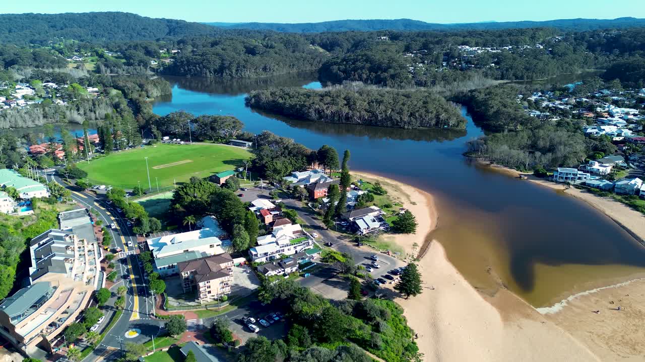 Paisaje aéreo con drones del lago y la laguna de Avoca Beach y la ensenada del canal de arena con viviendas residenciales costeras circundantes y la calle principal del centro de la ciudad, Costa Central, Nueva Gales del Sur, Australia, turismo de viajes, vacaciones