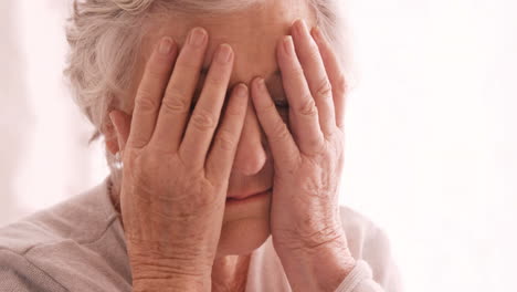 una anciana triste hablando por teléfono móvil.