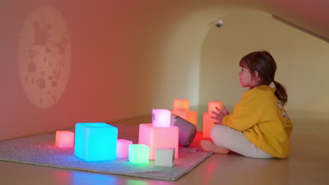 adorable niña estudiando dibujando acuarelas, exprimiendo agua colorida de la paleta pipeta en papel blanco sentada en el escritorio - vista elevada, cámara lenta