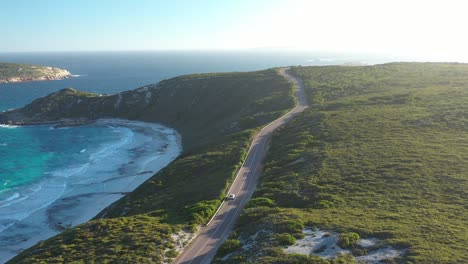 Excelente-Toma-Aérea-De-Autos-Conduciendo-A-Lo-Largo-De-Great-Ocean-Drive-En-Esperance,-Australia,-Mientras-Las-Olas-Lamen-La-Playa