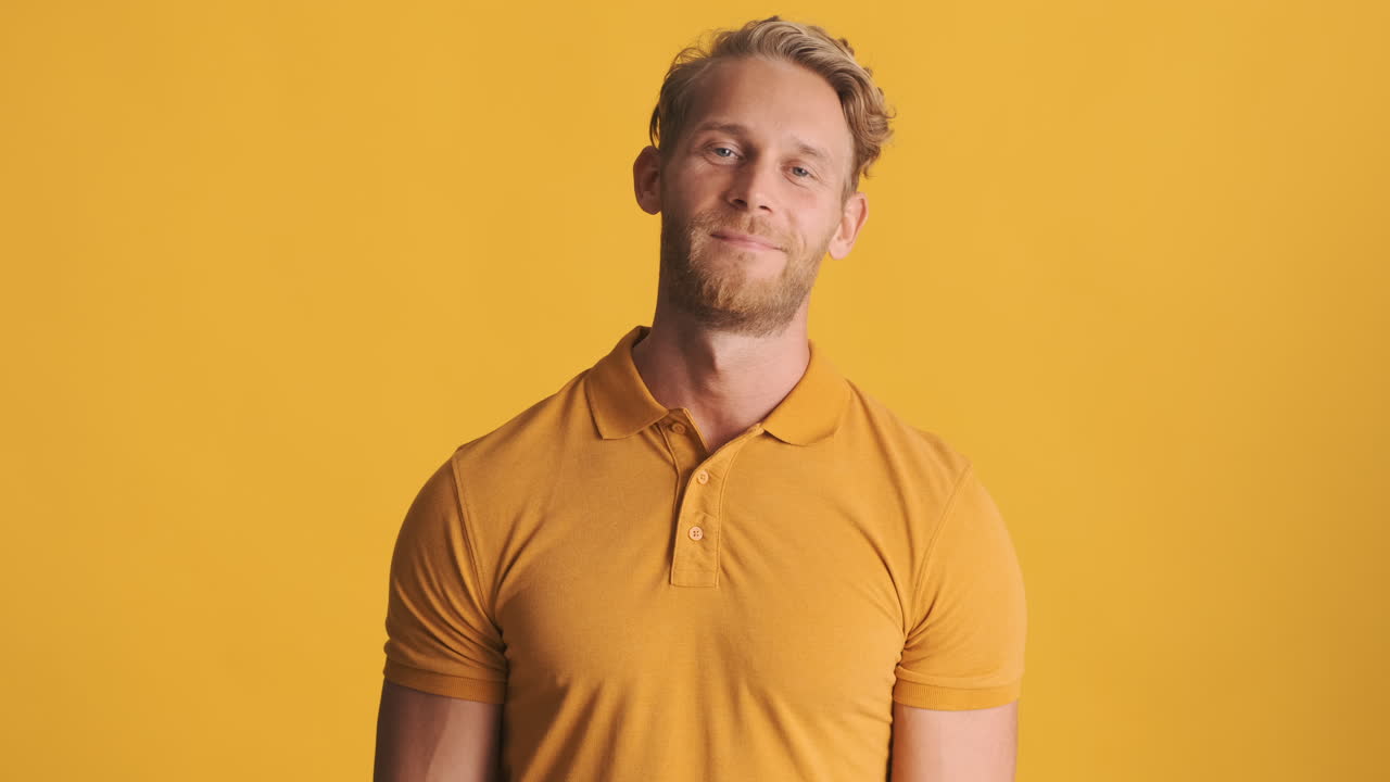 un chico rubio diciendo hola y agitando la mano.