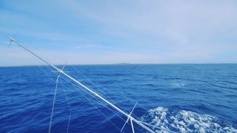 Outrigger-deep-sea-fishing-with-Curacao-landscape-visible-far-in-distance