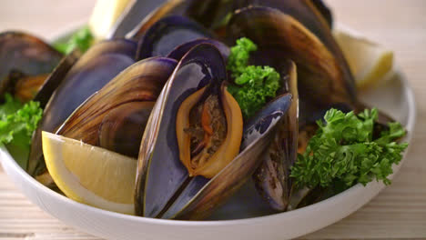 fresh mussels with herbs in a bowl with lemon