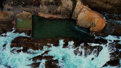 Ascending-Drone-of-Light-Blue-Waves-Crash-at-Bermagui-Blue-Pool,-Australia