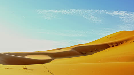 static shot over the sand dunes in the desert throughout the day in timelapse