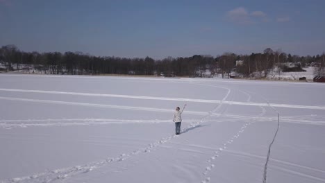 happy female waving at someone far away on the other side of a big lake while going for daily walk