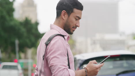 man using phone on city street