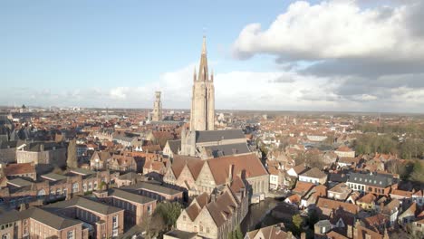 slow reveal drone shot of our lady church in bruges belgium on a sunny day