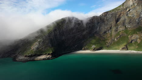 Drone-footage-of-clear-blue-waters-at-the-island-of-Vaeroy,-Lofoten-Islands-in-Norway