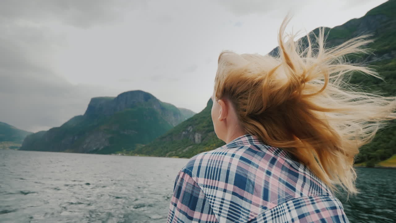 A Young Woman With Flowing Hair Is Standing On The Bow Of The Ship Looking Forward The Wind Blows In