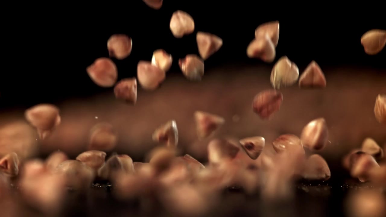 Buckwheat Grains Falling in Slow Motion on Black Background