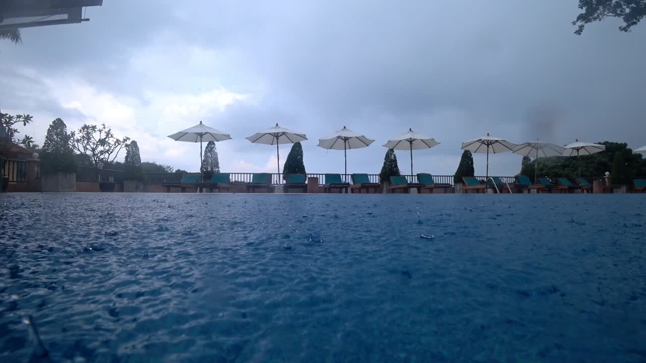 방울이 수영장 물 위에 떨어집니다.