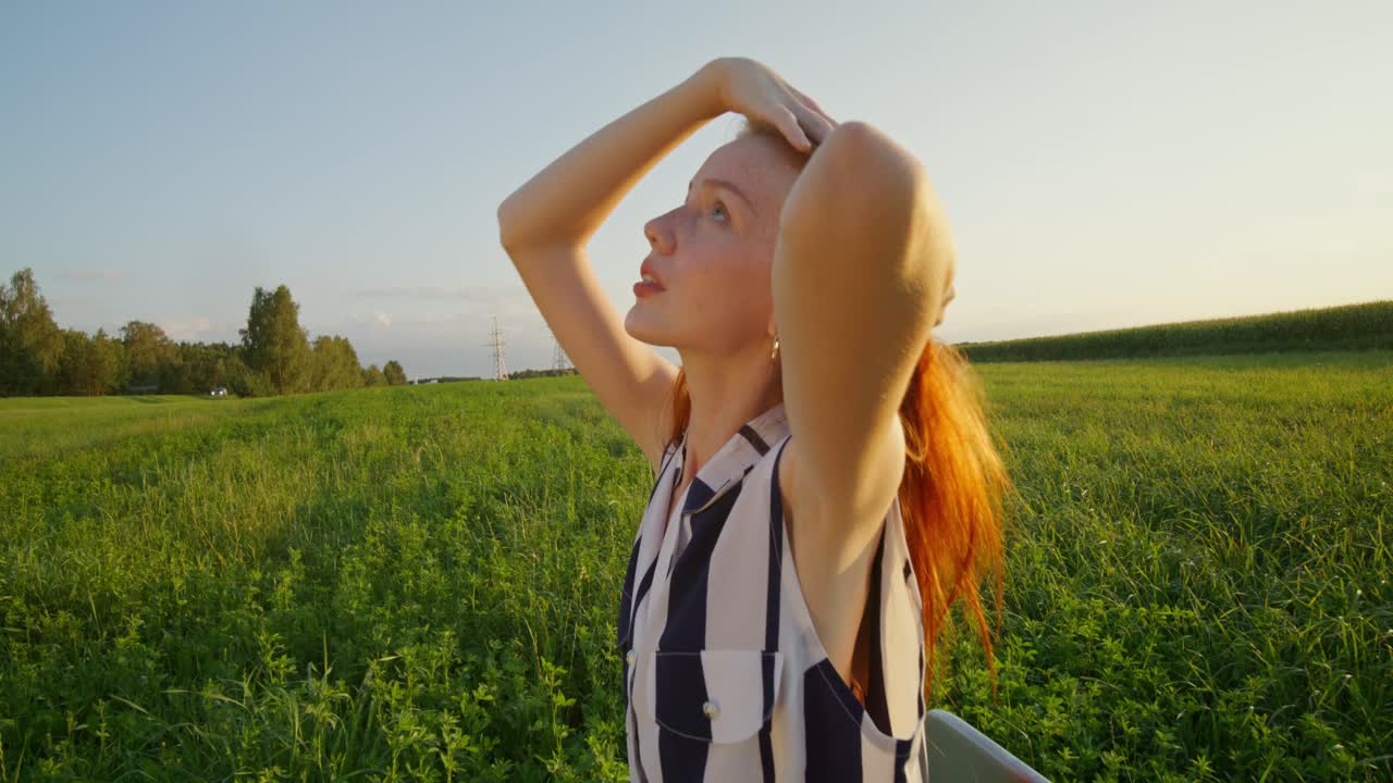 해가 지고 있는 들판 에 있는 젊은 여자