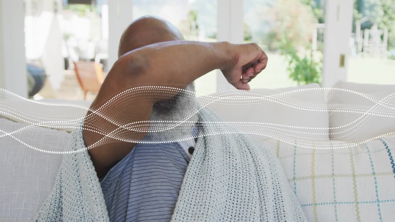 Un homme âgé bouge, lève le bras et s’essuie le visage, une vague pointillée traversant le milieu de l’image pour la santé