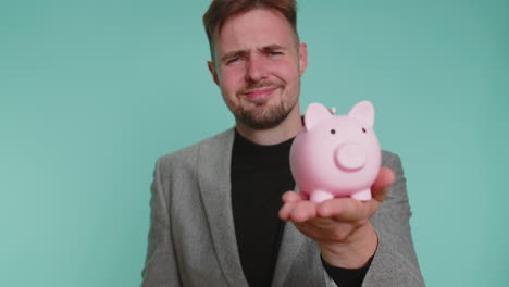 poor young business man holding piggybank and one dollar cash financial crisis bankruptcy poverty