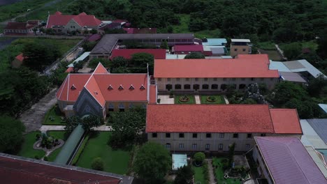 thủ thiêm parish church and the lovers of the holy cross convent are the oldest french colonial buildings in ho chi minh city, vietnam aerial view flying in over convent building on sunny day