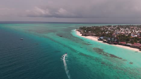 motorboat leaving wake in the surface of blue sea in nungwi, zanzibar, tanzania. - aerial shot