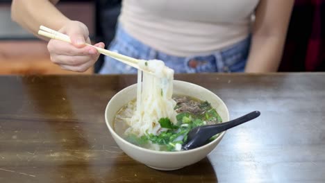 person enjoying a bowl of pho