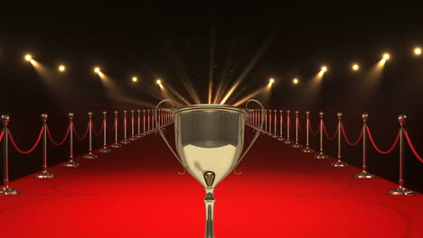 golden trophy over red carpet with spotlights and stanchions