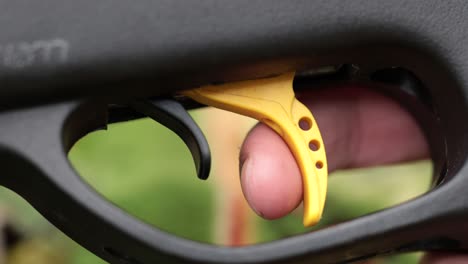 firing a gun, very close view of a finger pulling the trigger after removing the safety