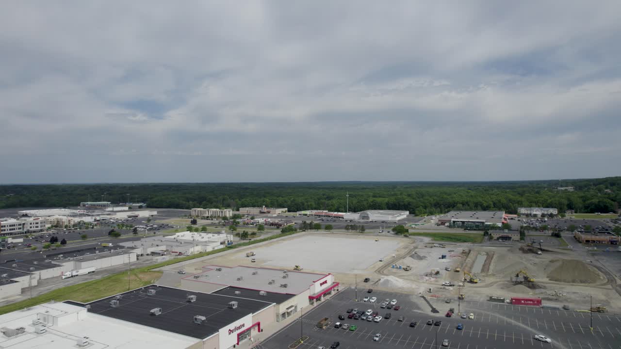 vista superior aérea del centro comercial con automóviles y lugares de estacionamiento vacíos cerca del sitio de construcción durante el día