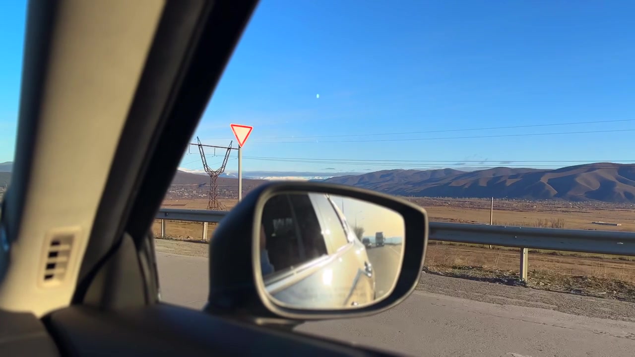 Vista dallo specchietto laterale dell'auto mentre si guida in autostrada